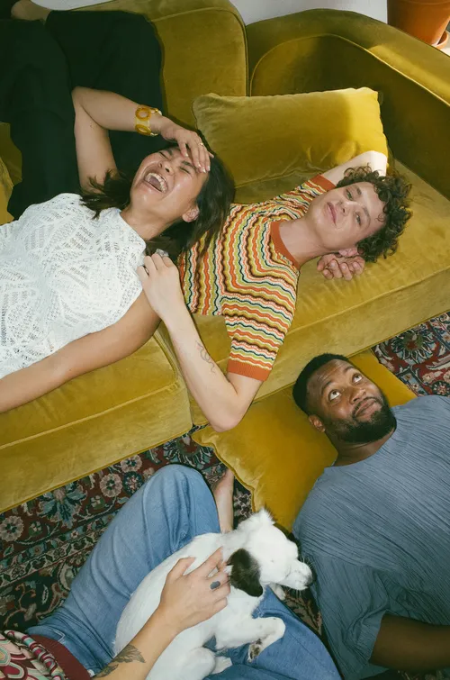 Friends relaxing on a couch with their dog